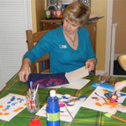 Denise with kids painting at table
